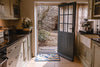Atlantic Mats recycled fish shoal design doormat in a rustic kitchen entryway.