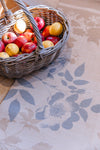 A wicker basket of apples and lemons on an Atlantic Mats Gold Rose recycled rug.