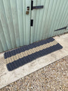 Extra large Atlantic Mats rope doormat with navy and cream stripes by a light green door