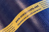 Close-up of a navy blue Atlantic Mats recycled ocean mat with a yellow care label.